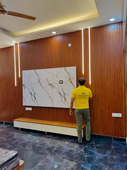 My team member giving the final touches to this full-wall TV unit. The dark wood fluting and integrated profile lights create a stunning effect.