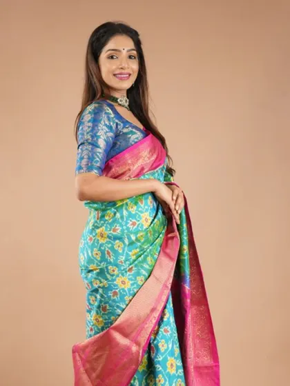A model wearing a beautiful Ikkat silk saree, paired with a contrasting blue brocade blouse. This look is a perfect example of how to style these vibrant weaves.