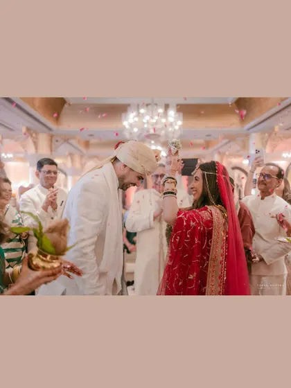 A candid moment during the wedding ceremony. The bride's playful gesture and the groom's smile show the friendship and love that underpins their marriage.