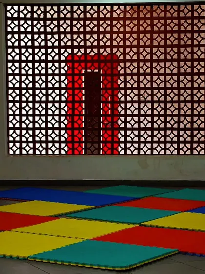 A playspace featuring a decorative jali screen. The pattern of the screen casts interesting shadows and provides ventilation while maintaining a sense of enclosure.