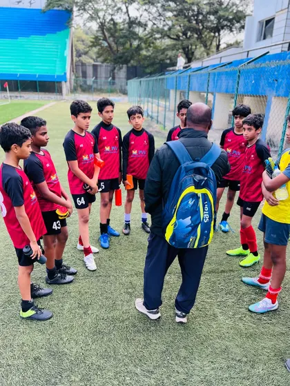 Mentorship is at the core of our coaching philosophy. Here, one of our certified coaches provides tactical instructions to the team during a break in play, ensuring every player understands their role and the team's strategy.