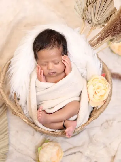 In this variation of the basket pose, the baby's hands gently frame their face. It’s a subtle change that creates a completely different feeling, highlighting their tiny fingers and peaceful expression.