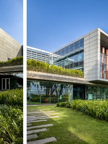 Two perspectives of the JSW Vasind administrative building, showcasing its distinct volumes and integration with the green landscape. The design uses a combination of glass, concrete, and stone to create a modern yet grounded aesthetic.