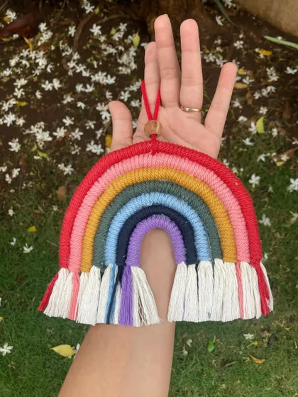 This custom rainbow wall hanging was created for a client and features a vibrant, multi-colored arc. It's a cheerful piece that can brighten up any room or even be used as a larger car charm.