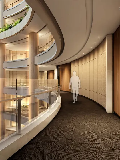 A view down a curved corridor in the Palais Royale atrium. The design uses warm wood paneling and soft, indirect lighting to create a sense of quiet luxury and seamless flow between private residences.