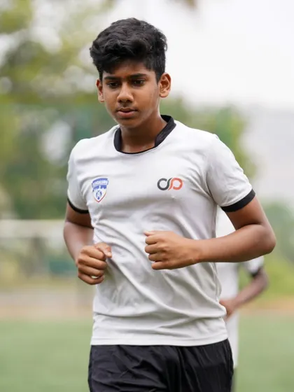 A young player's focused expression during a running drill reflects the discipline and determination required in our high-performance camp.