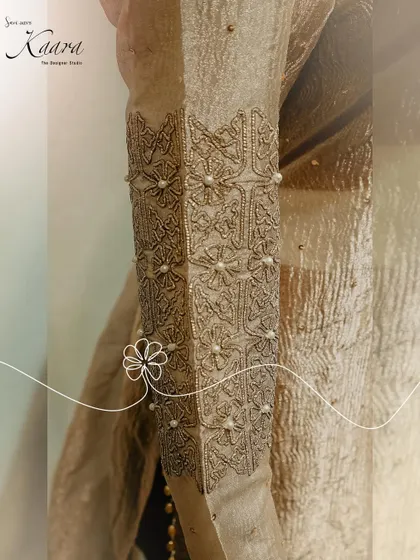 A close-up of the sleeve of our net kurti set. This image highlights the intricate sequin and pearl detailing, showcasing the delicate craftsmanship that goes into our lighter, more contemporary pieces.