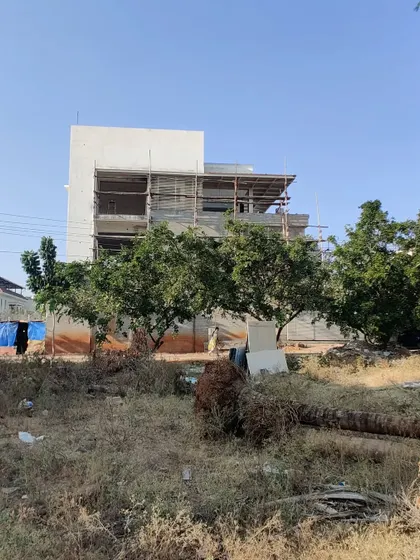 The house seen from across an empty plot, showing its context.