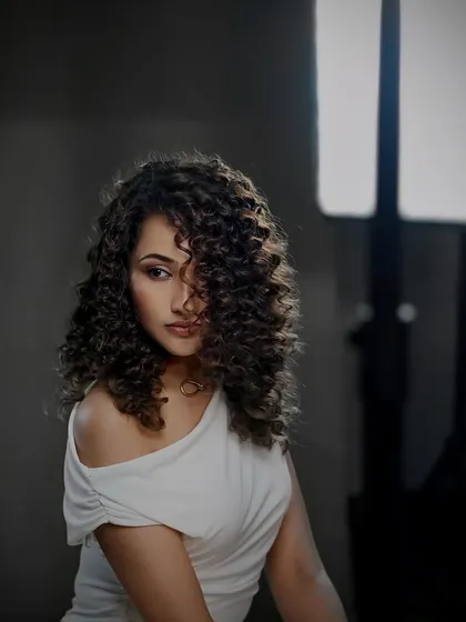 A dramatic, shadowy portrait of our curly-haired model from the campaign shoot.
