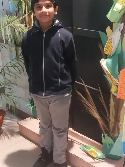 Posing proudly next to a corn-themed display at the school science fair. These events are a great way for kids to share what they've learned with a wider audience.