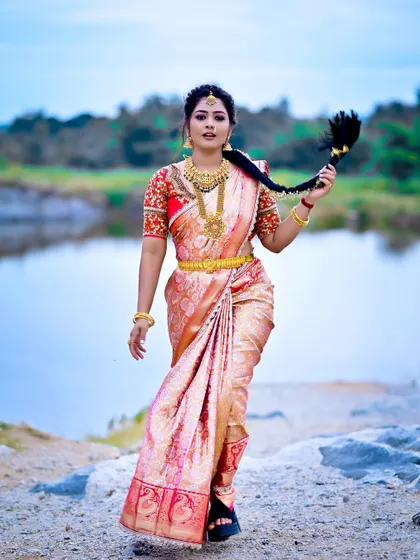 A full shot of the bride in her custom Muhurtham saree, showcasing the rich fabric and the detailed blouse work.
