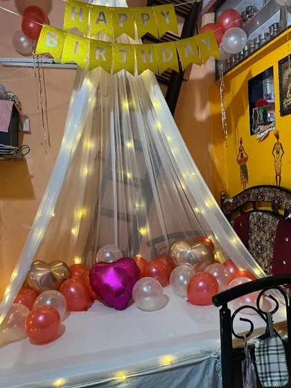 This version of the canopy room decor includes a 'Happy Birthday' banner. It shows how I can customize the setup for any special occasion, be it an anniversary, birthday, or just a romantic gesture.