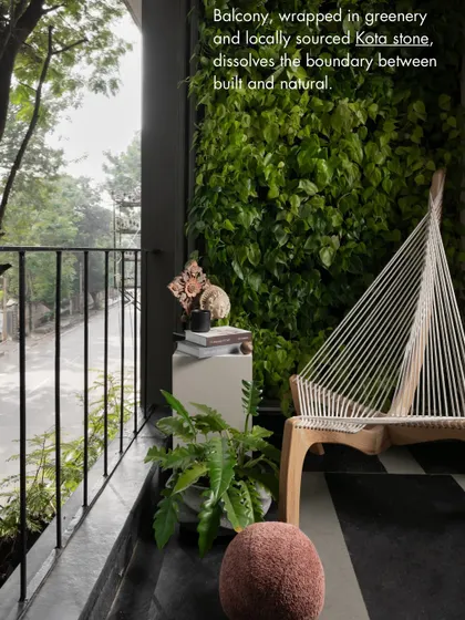 A balcony doesn't have to be an afterthought. Here, a vertical garden and locally sourced Kota stone flooring dissolve the boundary between the built and the natural, creating a serene urban oasis.
