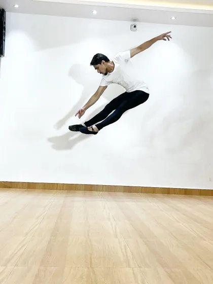 A powerful jump, or "grand jeté," frozen in mid-air. My training for male ballet dancers focuses on developing the power and technique needed for such athletic movements.