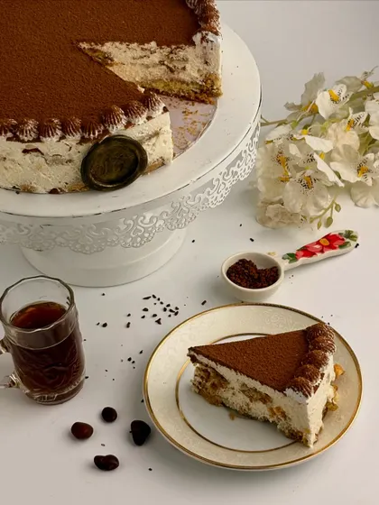 A perfect slice of my Tiramisu, revealing the distinct layers of coffee-soaked sponge and cream. It’s a bold, authentic dessert for true coffee lovers.