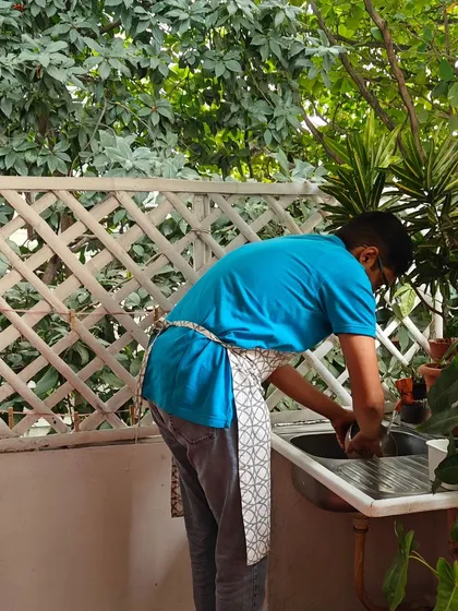 A parent practices a practical life activity, washing at a child sized sink. These tasks build independence, coordination, and a sense of responsibility, showing how everyday chores can be powerful learning opportunities.
