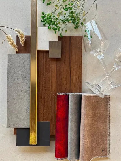 The material palette for 'Golden Glam', featuring wood, stone, metal, and rich red fabric to create a feeling of opulence.