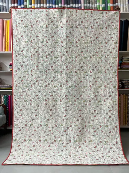 The backing fabric for the heart-themed baby clothes quilt, a simple and sweet floral print that complements the front.