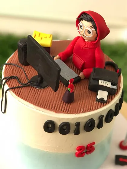A closer look at the coder-themed cake, showing the details of the miniature desk setup.