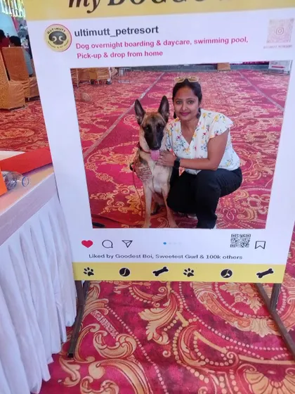 A proud pet parent joins her German Shepherd for a picture in the photo frame, a wonderful keepsake from their day at the pet-friendly Durga Puja.