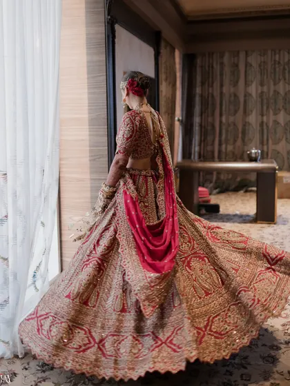 The bride twirls, showing off the beautiful flare of her intricate red lehenga.