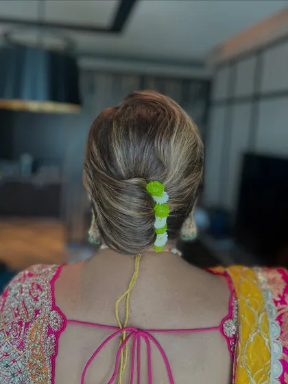 A back view of the modern French twist, showing the neat lines and the playful pop of color from the flowers.