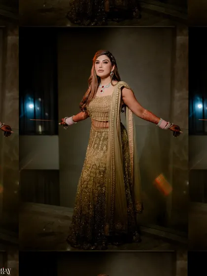 A stunning solo portrait of the bride in her golden lehenga, captured with dramatic lighting.