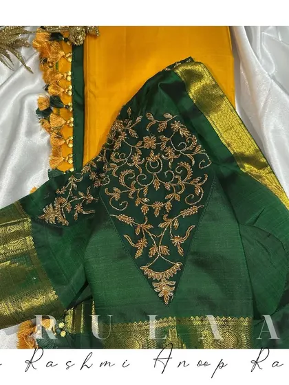 The back view of the green blouse, showing a diamond-shaped panel of embroidery. The custom tassels on the dori are made to match the saree.