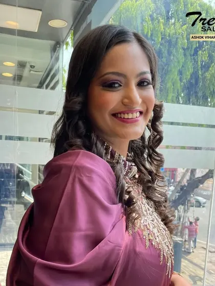 A happy client showing off her party-ready look. The makeup features a smokey eye and a bright smile, perfect for celebrating any special occasion with confidence.