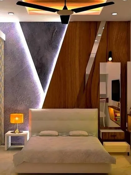 A modern bedroom with a dramatic, angular feature wall. The integrated lighting highlights the different textures of wood and stone, and the built-in dressing table is a clever use of space.