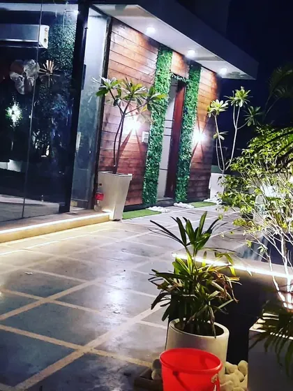 This beautiful night shot shows a prefab room with natural wood cladding and vertical garden accents, creating a warm and inviting entrance.