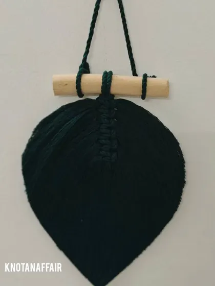 Another look at the bottle green macrame leaf, hung on a wooden dowel. These can be made in various shades to create a beautiful wall decor arrangement.