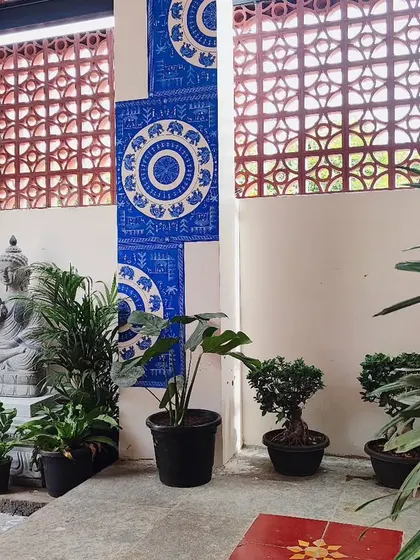 A tranquil courtyard corner I designed, featuring a Ganesha statue surrounded by a variety of plants like palms, monstera, and bonsai.