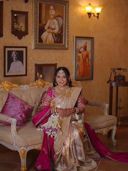 The glowing mother-to-be, seated in a regal setting. Her traditional look is completed with our fresh floral kalire and hair accessories.