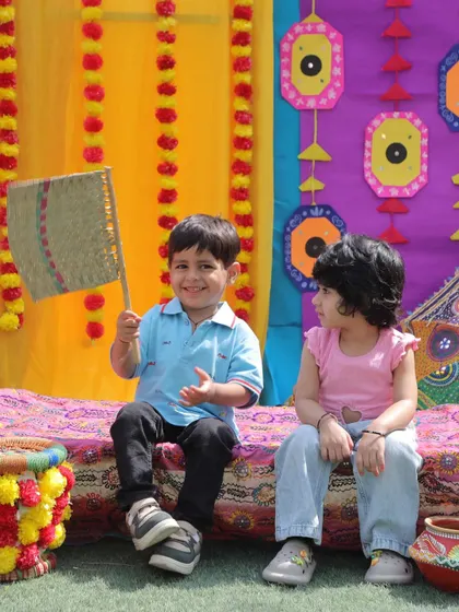 Two friends enjoying the festive setup during our Baisakhi celebration. The colorful decor and traditional props created an immersive cultural experience for the children.