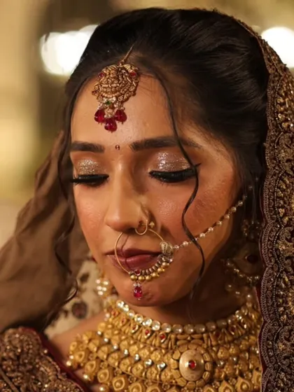 A detailed close-up of the bridal eye makeup. The combination of gold glitter and soft brown shadows creates a warm, captivating effect.