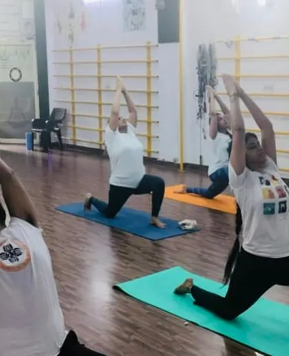 Members in Anjaneyasana, the crescent lunge pose. This is a deep stretch for the hips and quads, and it also challenges your balance.