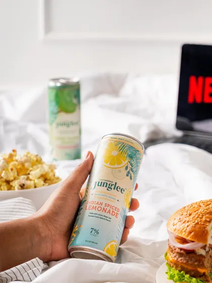 A "Netflix and chill" themed lifestyle shot for a canned cocktail brand. This connects the product with popular, relatable moments.