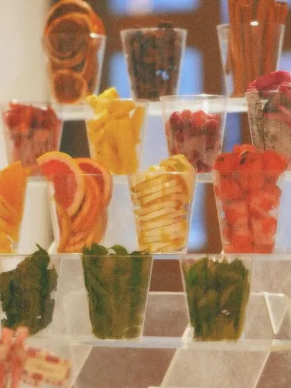 A creative and healthy bar setup featuring fresh fruit and herb garnishes. This is a great way to elevate the drink station and add a splash of color.