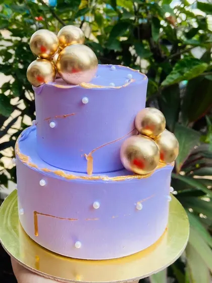I love creating these mini two-tier cakes for intimate New Year celebrations. This elegant lavender cake is decorated with gold spheres and pearl details for a touch of glamour.