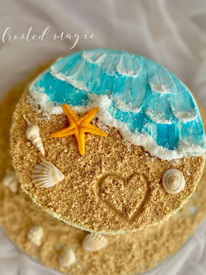 I love creating textures that you can almost feel, like the edible sand on this beach-themed cake. The gentle buttercream waves, hand-moulded shells, and a little heart drawn in the "sand" make this a perfect cake for anyone who loves the ocean.