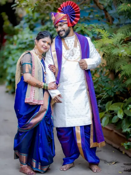 A full-length portrait of the couple in their striking royal blue and white traditional attire, exuding elegance.