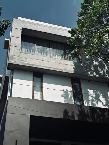 The strong geometry of this exposed concrete frame defines the upper level, creating a bold window aperture that frames the view from within.