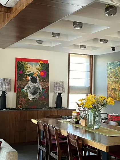 The 'Recuperation' painting installed in its new home, a modern dining area. The artwork's vivid colors and surreal imagery bring a unique energy and conversation point to the space.