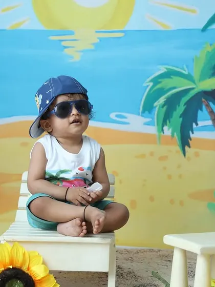 Another cool pose from the beach-themed session, with the toddler looking away with his sunglasses on.