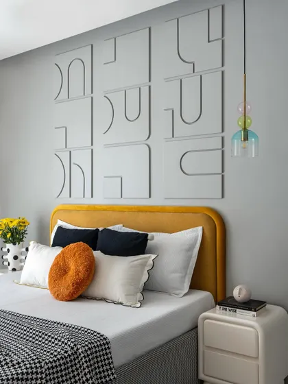 This bedroom showcases playful yet sophisticated design with a custom 3D wall art piece above a mustard-yellow headboard. The colorful glass pendant light adds a whimsical touch, creating a space that is both fun and stylish.