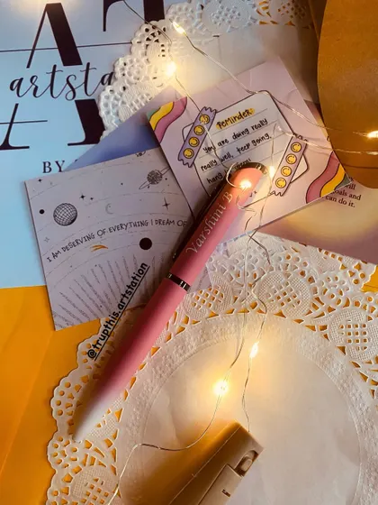 This shot shows the personalized pen surrounded by fairy lights, highlighting the custom engraving. It's a great addition to a gift hamper or as a standalone present for a student or professional.