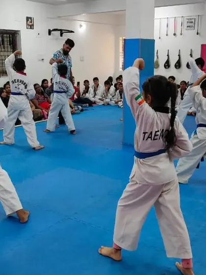 A different angle of the blue belt students practicing their upper block.