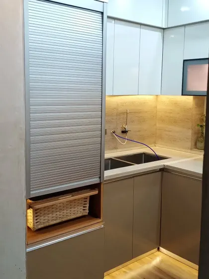 This unit includes a rolling shutter and a wicker basket, providing convenient storage for appliances and produce.