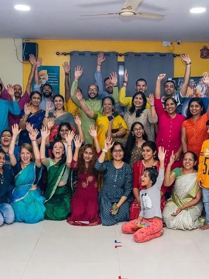 The joyful culmination of our Bhakti Immersion Kirtan event. The entire group is seen with hands raised, celebrating the uplifting power of singing together and sharing in a collective spiritual experience.